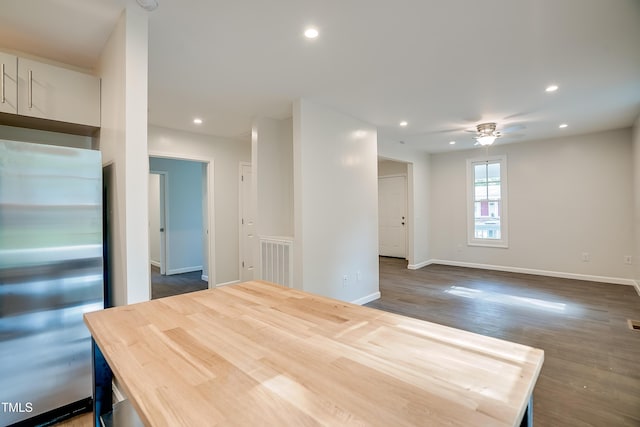 interior space featuring stainless steel fridge, ceiling fan, and dark hardwood / wood-style floors