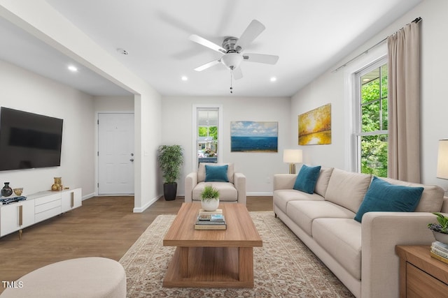 living room with wood finished floors, plenty of natural light, baseboards, and recessed lighting