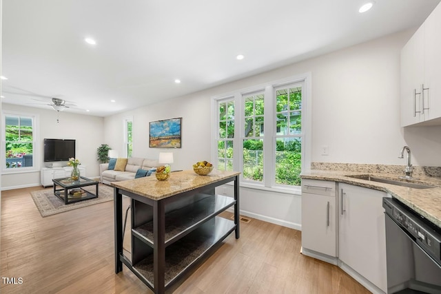 kitchen featuring dishwashing machine, a sink, recessed lighting, white cabinetry, and light wood-style floors