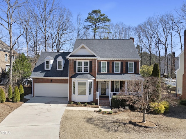 view of front facade featuring an attached garage, concrete driveway, brick siding, and a porch