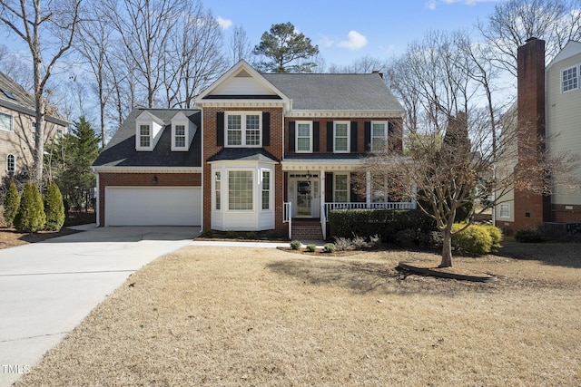 view of front facade featuring covered porch, concrete driveway, brick siding, and an attached garage