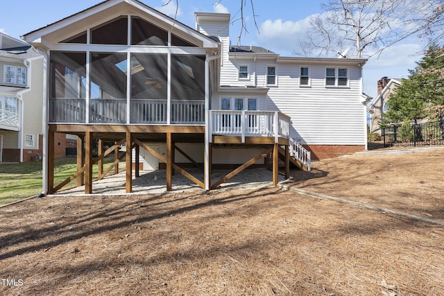 back of house featuring a sunroom, a deck, and stairs