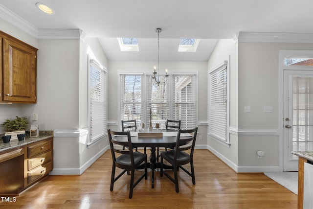 dining space featuring an inviting chandelier, crown molding, and light wood-style floors