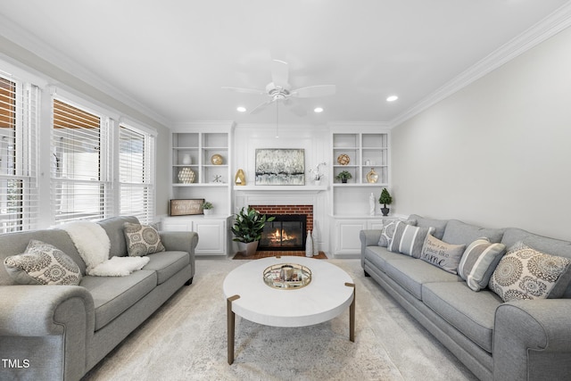 living room with ornamental molding, a brick fireplace, built in shelves, and recessed lighting