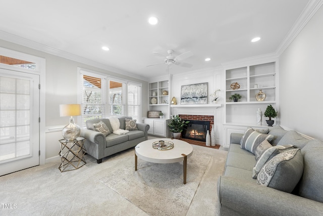 living area featuring light carpet, a fireplace, built in features, and crown molding