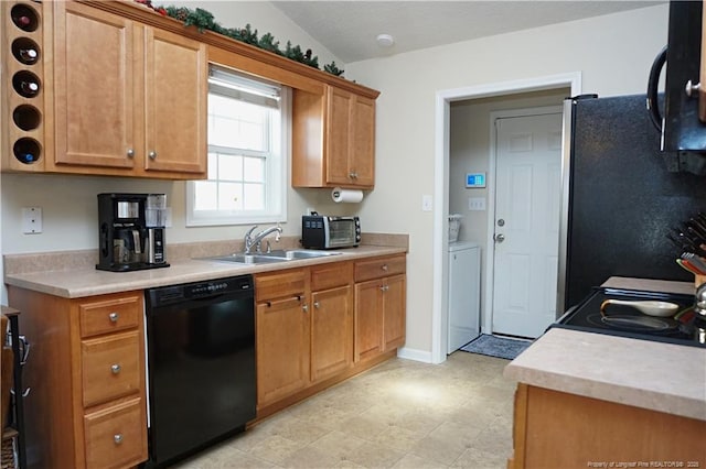 kitchen featuring black appliances, lofted ceiling, and sink