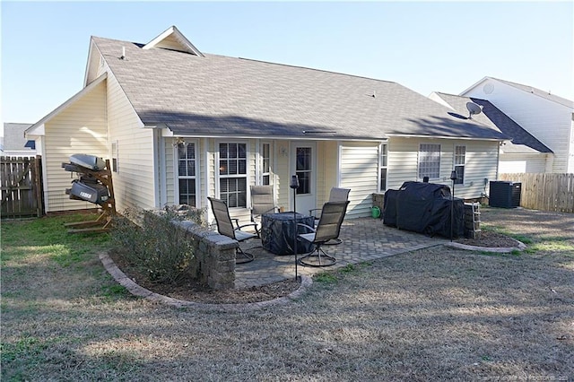 back of property featuring a yard, cooling unit, and a patio area