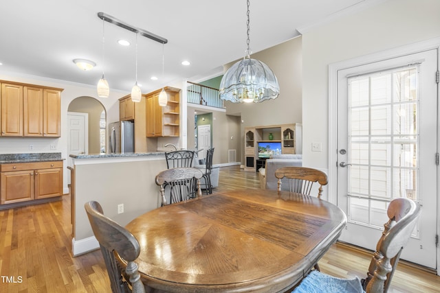 dining room with a chandelier, crown molding, and light hardwood / wood-style floors