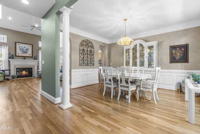 dining area featuring light hardwood / wood-style floors, a wealth of natural light, crown molding, and ceiling fan with notable chandelier