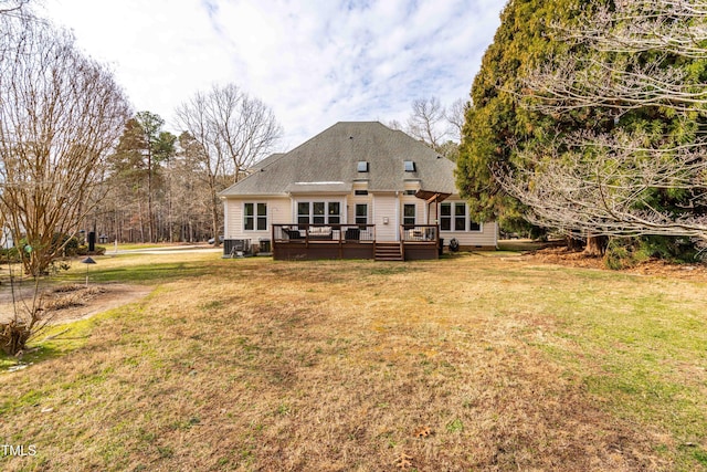 rear view of property with a yard, a deck, and central AC