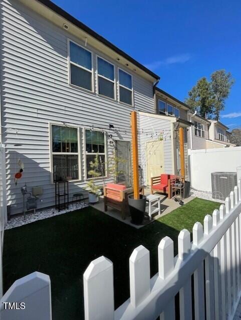 back of property featuring a lawn, cooling unit, and a patio