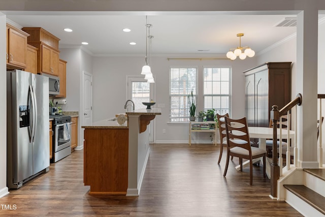 kitchen with light stone countertops, crown molding, stainless steel appliances, and pendant lighting