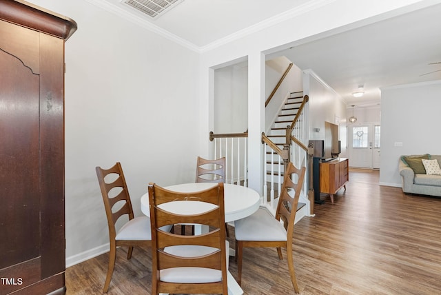 dining space with light hardwood / wood-style floors and crown molding