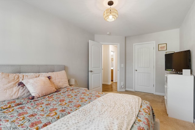 carpeted bedroom with an inviting chandelier