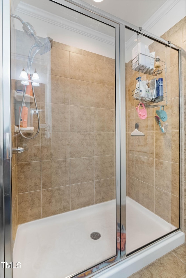 bathroom featuring a shower with door and crown molding