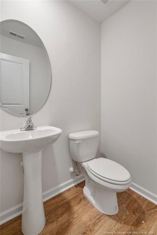 1114 Talmage Rd, Saint Pauls, NC 28384 - bathroom with wood finished floors, toilet, and baseboards