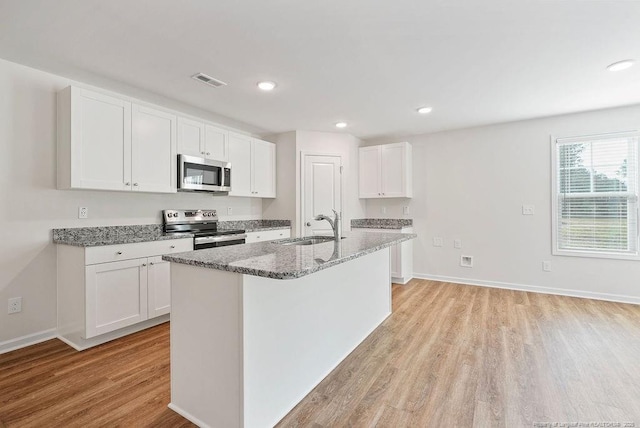 1114 Talmage Rd, Saint Pauls, NC 28384 - kitchen with appliances with stainless steel finishes, a sink, light wood-style floors, light stone countertops, and white cabinets