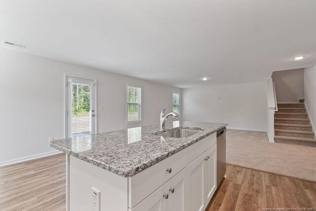 1114 Talmage Rd, Saint Pauls, NC 28384 - kitchen featuring a sink, stainless steel dishwasher, open floor plan, light stone counters, and white cabinets