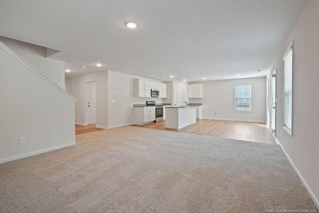 1114 Talmage Rd, Saint Pauls, NC 28384 - unfurnished living room with light carpet, baseboards, and recessed lighting