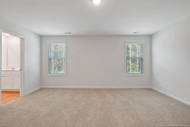 1114 Talmage Rd, Saint Pauls, NC 28384 - spare room featuring light carpet, baseboards, and a sink