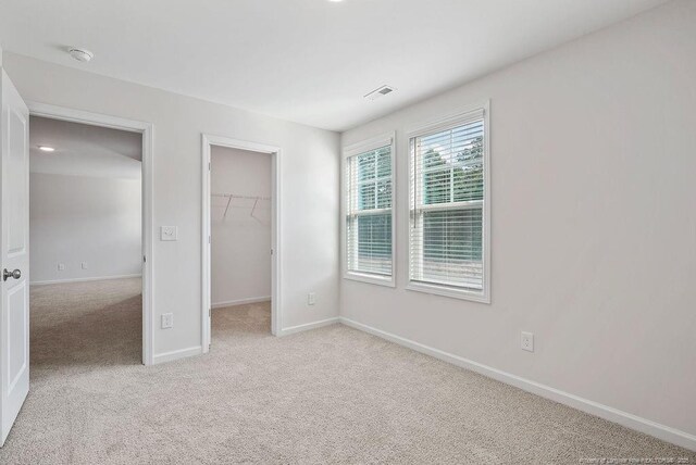 1114 Talmage Rd, Saint Pauls, NC 28384 - unfurnished bedroom featuring light carpet, a walk in closet, baseboards, and a closet