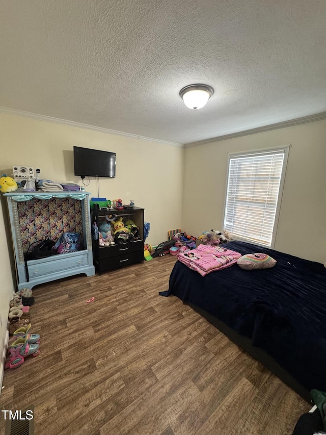 bedroom with a textured ceiling, ornamental molding, and hardwood / wood-style floors