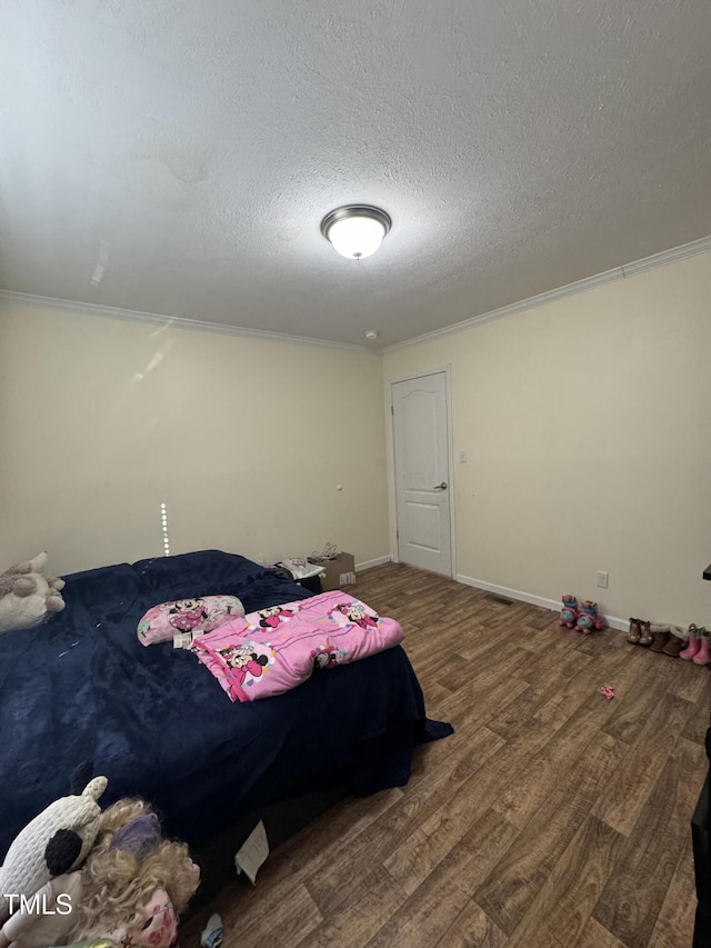 bedroom with hardwood / wood-style flooring, a textured ceiling, and crown molding