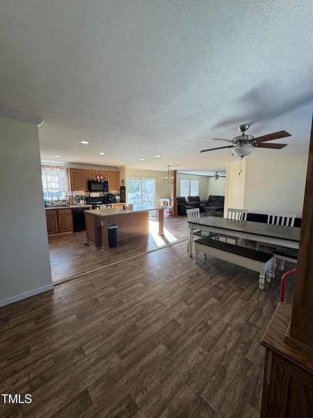 living room featuring a textured ceiling, dark wood-type flooring, sink, and ceiling fan