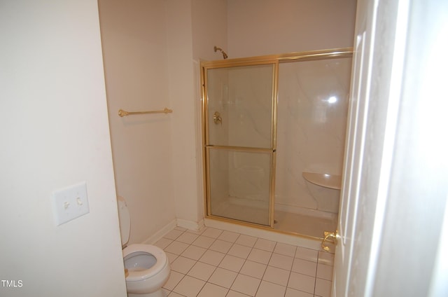 bathroom featuring toilet, tile patterned flooring, and a shower with shower door