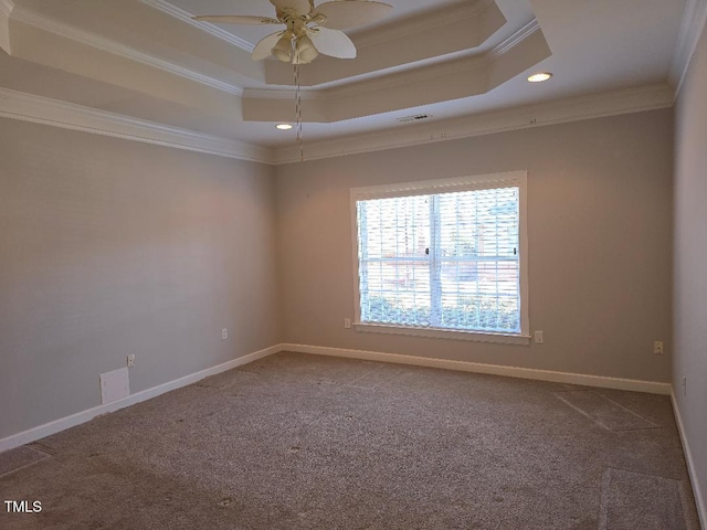 carpeted empty room featuring a raised ceiling, ceiling fan, and ornamental molding