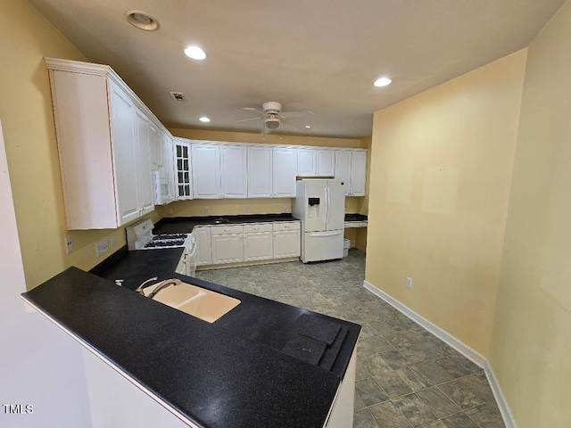 kitchen with sink, white cabinets, white appliances, ceiling fan, and kitchen peninsula