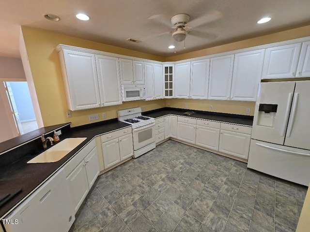 kitchen featuring white appliances, white cabinets, ceiling fan, and sink