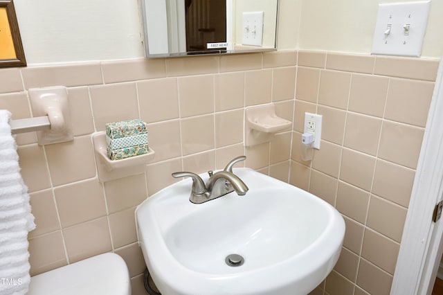 bathroom featuring sink and tile walls