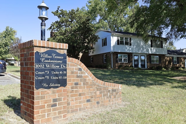 community / neighborhood sign featuring a yard