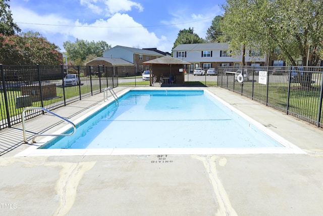 view of swimming pool with a lawn