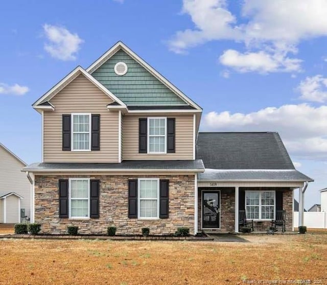 view of front of property with stone siding and a front lawn