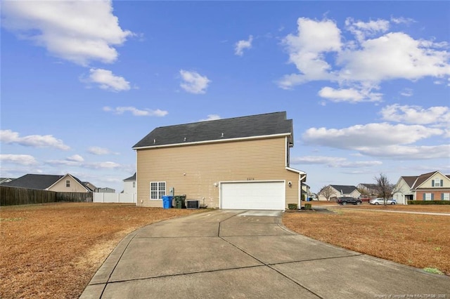 view of property exterior featuring cooling unit, concrete driveway, and fence