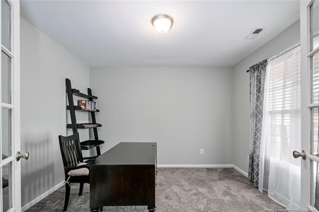 carpeted office space featuring french doors, visible vents, and baseboards