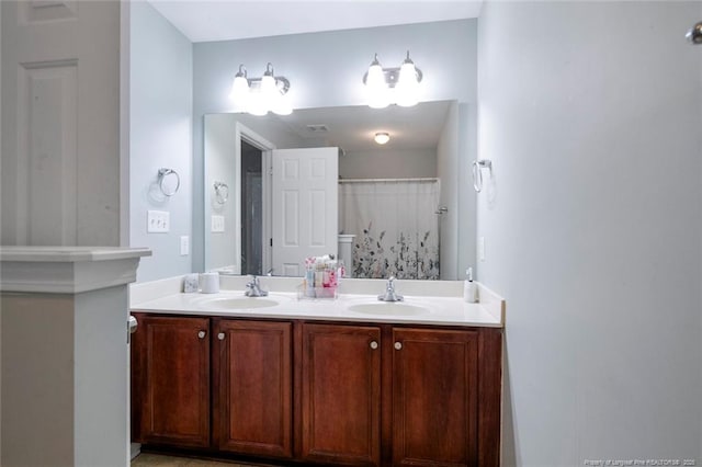 full bathroom with double vanity and a sink