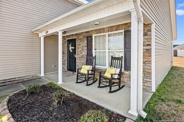 doorway to property with stone siding and a porch