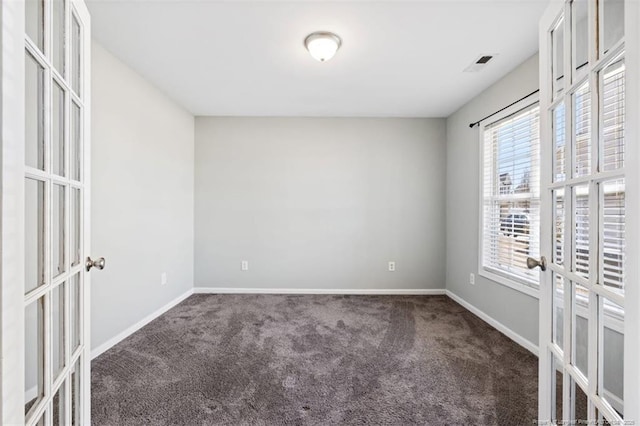 carpeted empty room with french doors, visible vents, and baseboards