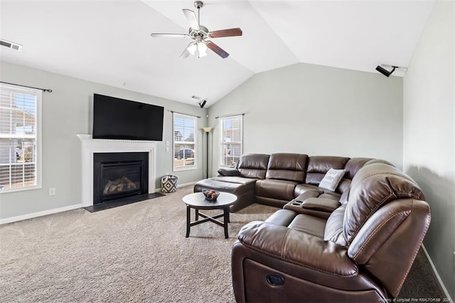 carpeted living area featuring visible vents, a healthy amount of sunlight, lofted ceiling, and a ceiling fan