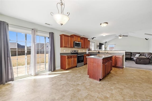 kitchen featuring pendant lighting, open floor plan, appliances with stainless steel finishes, lofted ceiling, and ceiling fan