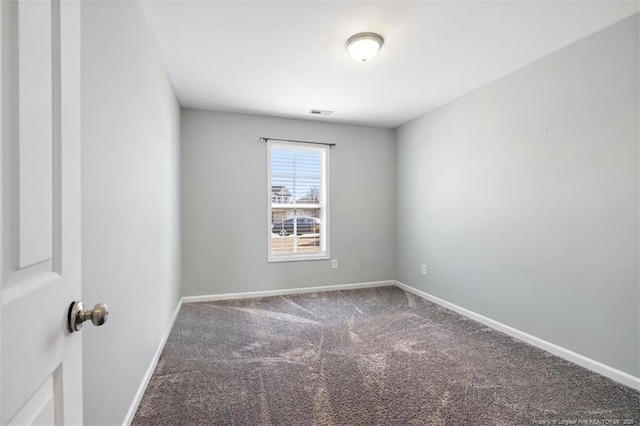 spare room featuring carpet flooring and baseboards