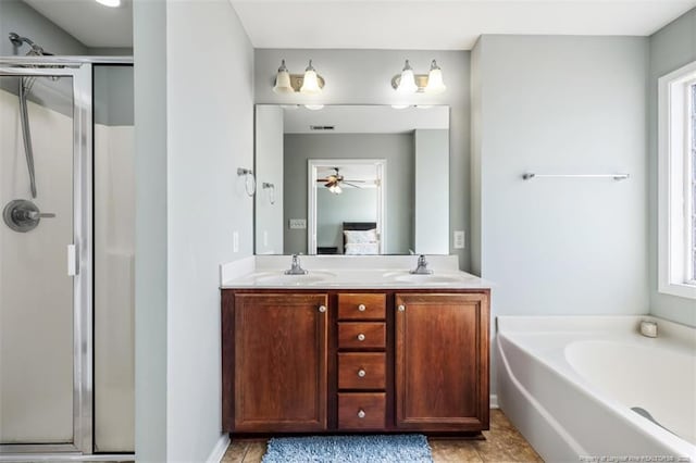 bathroom with a shower stall, a healthy amount of sunlight, double vanity, and connected bathroom