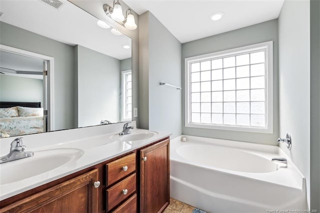 ensuite bathroom featuring a garden tub, double vanity, ensuite bathroom, and a sink