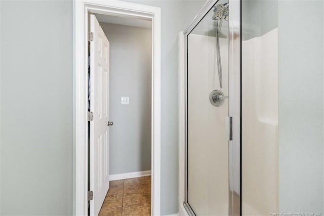 full bath with tile patterned flooring, a shower stall, and baseboards