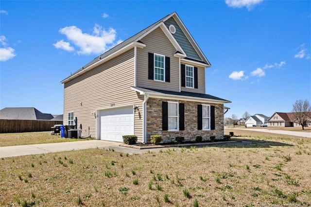 view of front of property with a front lawn, driveway, stone siding, fence, and an attached garage