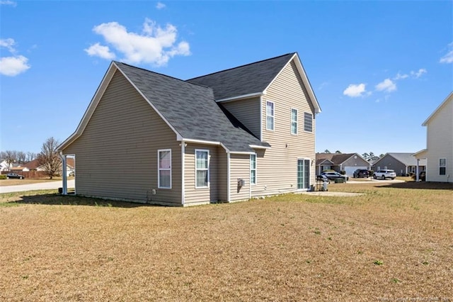 view of home's exterior with a lawn and roof with shingles