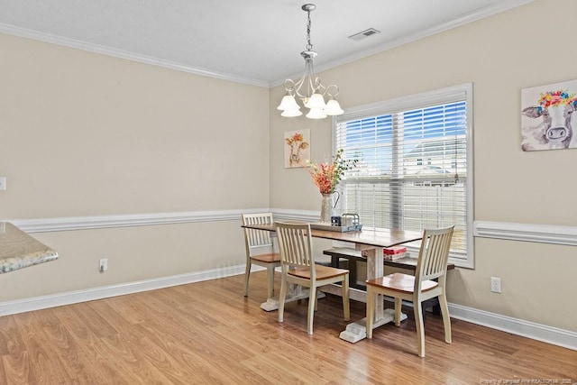 dining room featuring light hardwood / wood-style floors, an inviting chandelier, and ornamental molding